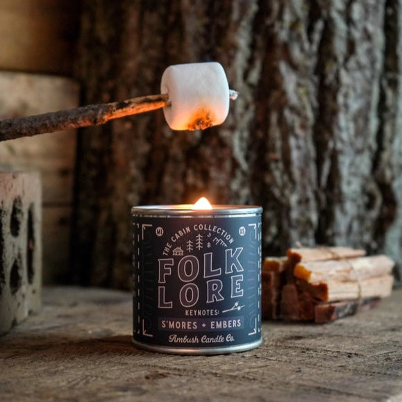 Folklore candle with marshmallow being roasted over a campfire