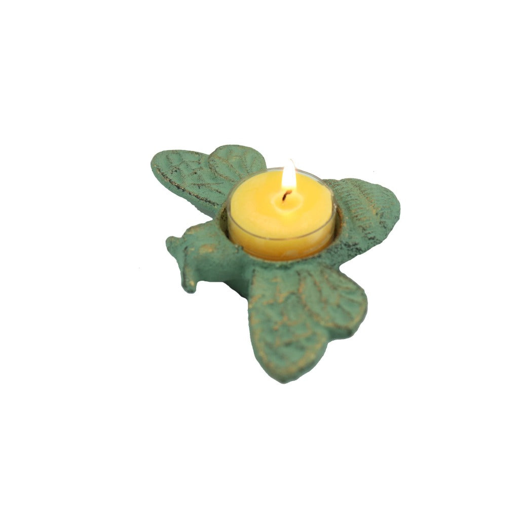 Beeswax tea light candle lit in a antique green cast iron bee tea light candle holder. - Candlestock.com
